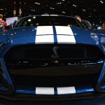 The front of a blue 2020 Ford Mustang Shelby GT500 with white racing stripes
