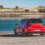 the back of a red VW Golf GTI in front of a lake