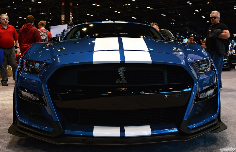 The front of a blue 2020 Ford Mustang Shelby GT500 with white racing stripes